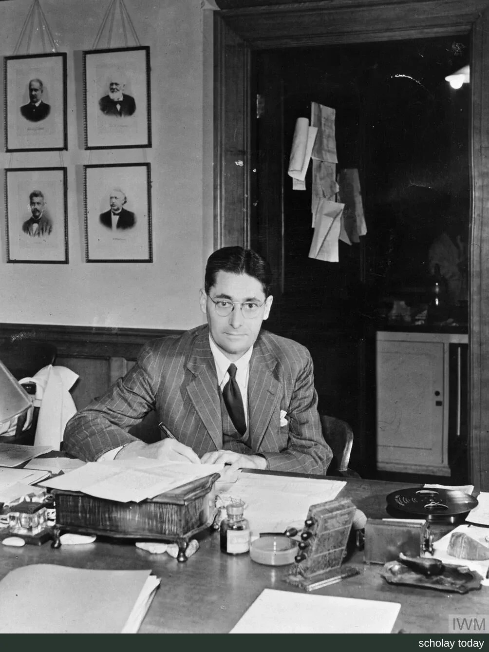 1944 年霍华德·弗洛里坐在牛津威廉·邓恩爵士病理学院的办公桌前,低头书写笔记